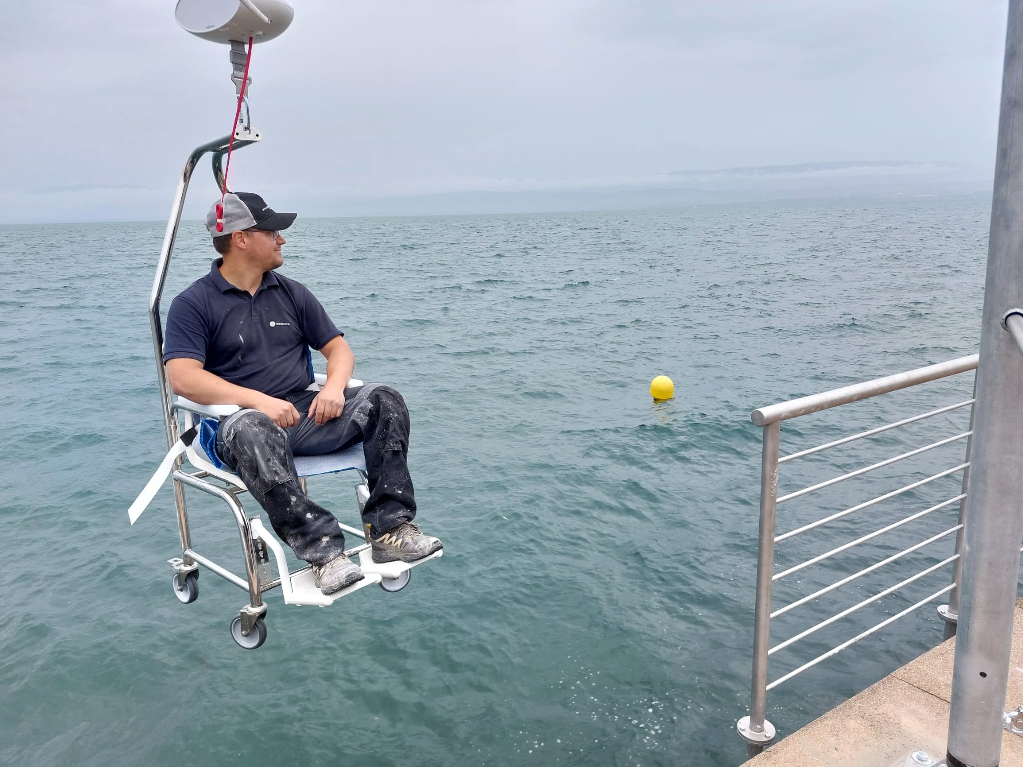 Photo d'une potence avec une chaise et un moteur de levage de la marque Guldmann (OsmosO handicap)