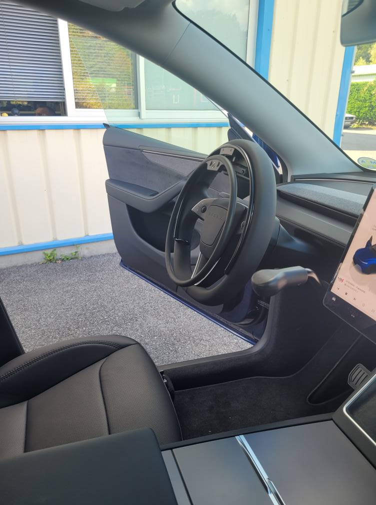 Tesla Model Y 2025 équipée d’un cercle accélérateur KS sur volant et d’un frein manuel LF901, pour conduite accessible aux personnes à mobilité réduite.