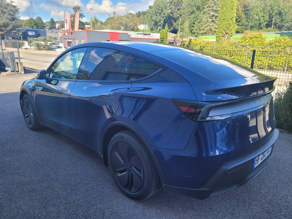 Tesla Model Y 2025 équipée d’un cercle accélérateur KS sur volant et d’un frein manuel LF901, pour conduite accessible aux personnes à mobilité réduite.