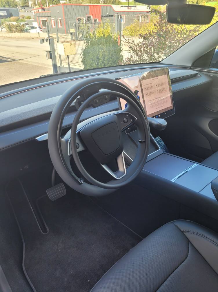 Tesla Model Y 2025 équipée d’un cercle accélérateur KS sur volant et d’un frein manuel LF901, pour conduite accessible aux personnes à mobilité réduite.